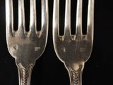 pair of silver plated forks on a black background