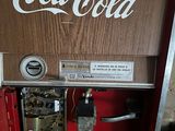 a coca cola machine that is sitting inside of a building