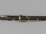 a close up of a clarinet on a white surface