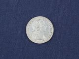 a close up of a silver coin on a blue cloth