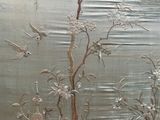 une photo d'un mur orné d'une peinture représentant des oiseaux et des fleurs