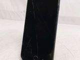 an iphone with a cracked screen sitting on top of a table