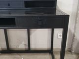 the desk is black and has two drawers on it