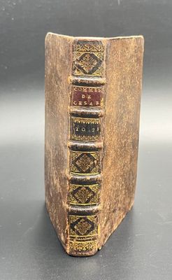 an old book sitting on top of a table next to a black table