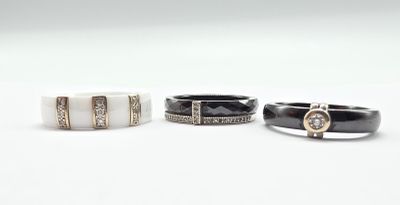 three black and white rings with diamonds on them on a white surface