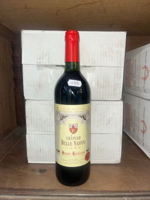 une bouteille de vin posée sur une étagère devant une pile de cartons