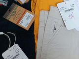 a pile of men ' s clothing on a table with tags on it