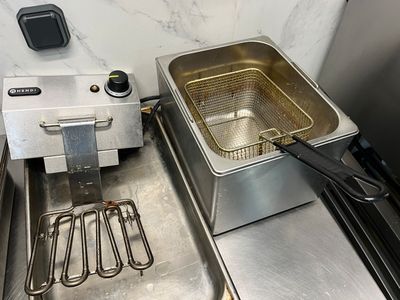 une friteuse posée sur un plan de travail à côté d'un évier