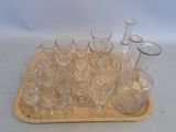 bottles and glasses on a tray on a white surface