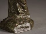 a statue of a woman holding a bird on a rock