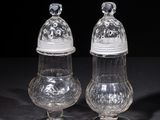 two clear glass salt and pepper shakers on a black surface