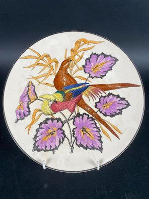 a plate with a bird and flowers painted on it