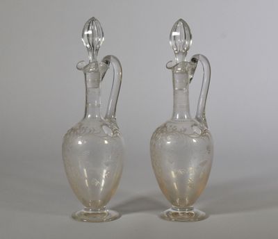two clear glass vases sitting on top of a white table