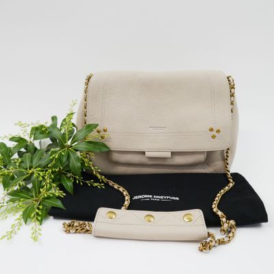 a white and black purse with a plant on top of it