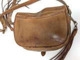 an old brown leather purse with a tassel hanging from it ' s side