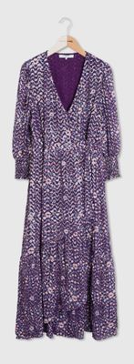 une robe violette et blanche suspendue à un cintre devant un mur blanc