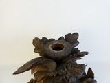 a wooden sculpture of a pine cone with a bird on it