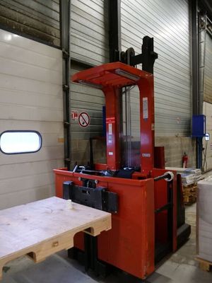 a fork lift truck in a warehouse with pallets and boxes