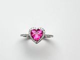 une bague rose en forme de cœur sertie de diamants sur fond blanc