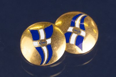 une paire de boutons de manchette en or et émail bleu sur un fond noir