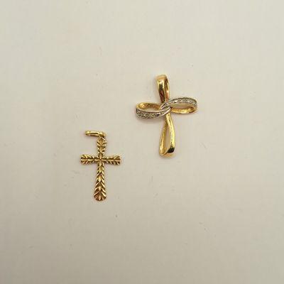 deux croix en or et une croix en diamant sur un fond blanc