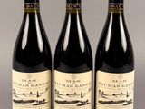 trois bouteilles de vin sont alignées sur une table