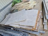un tas de bois posé sur le sol à côté d'un bâtiment