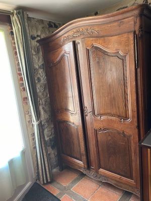 a large wooden armoire in the corner of a room