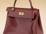 a red leather handbag with a gold lock on the handle