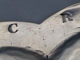 a close up of a silver spoon with the letter c on it