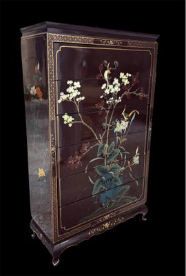 une armoire sur laquelle sont peintes des fleurs sur fond noir