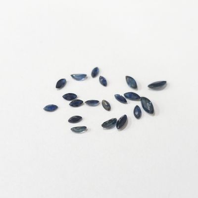quelques perles de verre bleu foncé sont dispersées sur une surface blanche