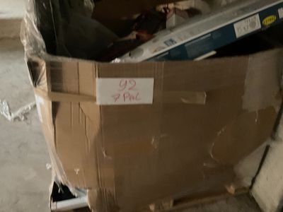 une boîte en carton sur laquelle est accrochée une pancarte, posée dans une pièce