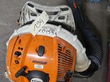 a chainsaw and a blower sitting on the ground