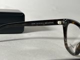 glasses are sitting on a white surface next to a black box