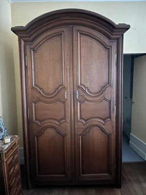 une grande armoire en bois dans le coin d'une pièce