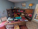 une photo d'un bureau à domicile avec un bureau et une bibliothèque