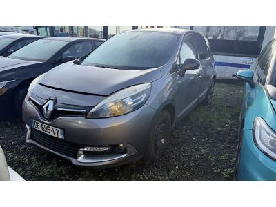 La voiture grise est garée à côté d'autres voitures sur le parking.