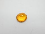 gros plan d'une pierre de saphir jaune sur une surface blanche