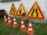 Plusieurs panneaux de signalisation sont alignés sur l'herbe