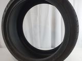 a close up of a tire on a white surface with a curtain in the background