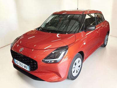 La voiture rouge est garée sur le sol blanc de la pièce.
