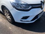 the front end of a white car parked in a parking lot