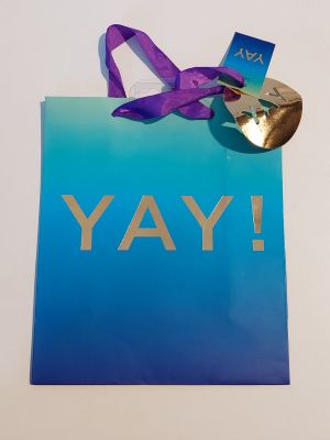a blue bag with a purple ribbon and a medal on it