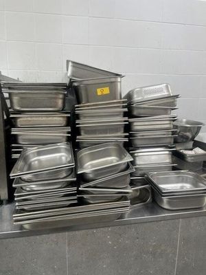 many pans stacked on top of each other in the kitchen