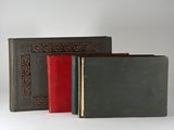 trois livres sont alignés sur une surface blanche