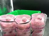 six pink plastic cups are lined up on a counter