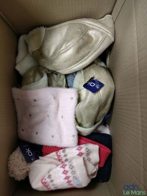 une boîte en carton remplie de vêtements et d'une peluche