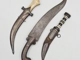 two old knives are sitting next to each other on a white surface