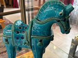 une figurine de cheval bleu exposée dans une vitrine